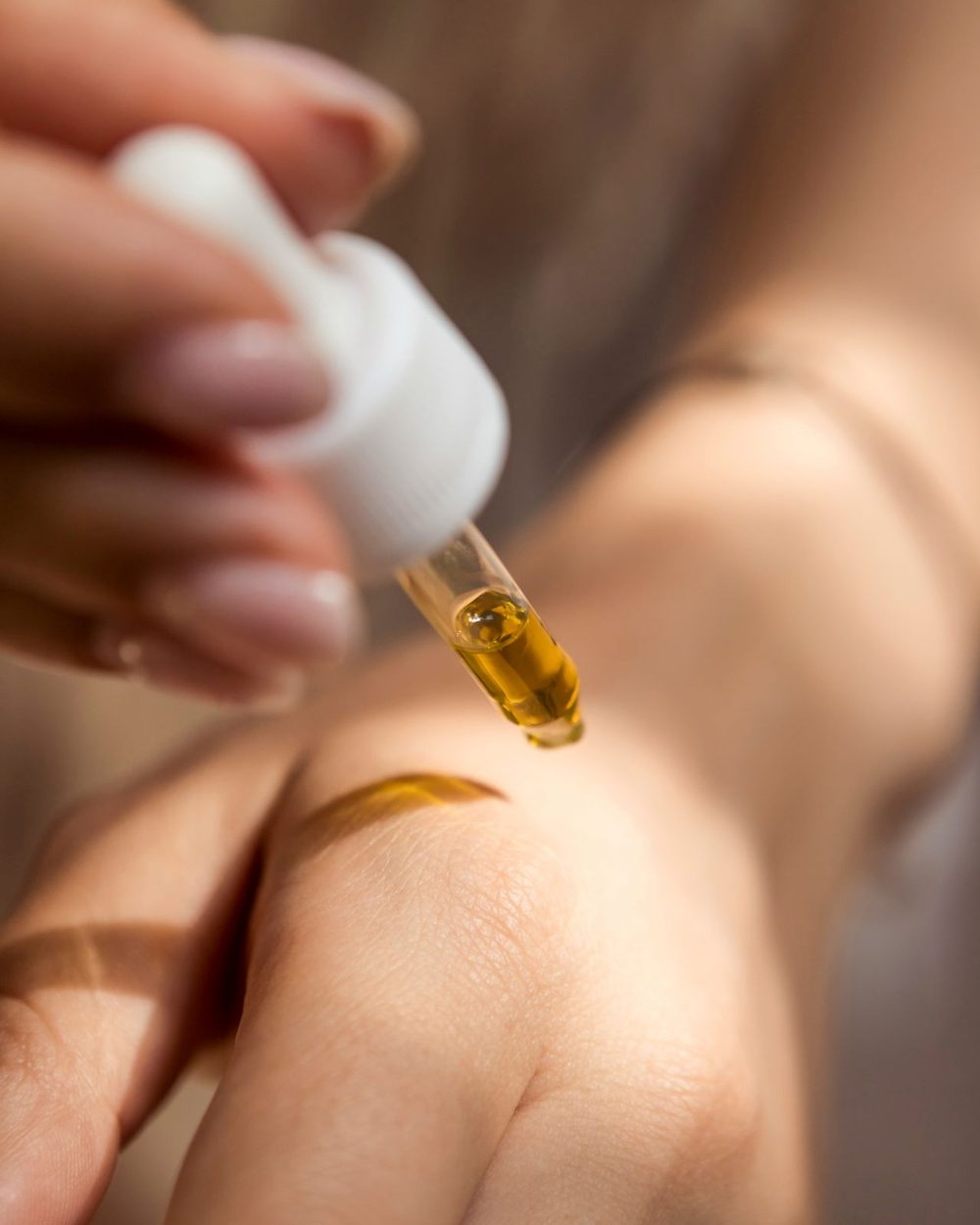 Huile déposée à la pipette sur le dos de la main